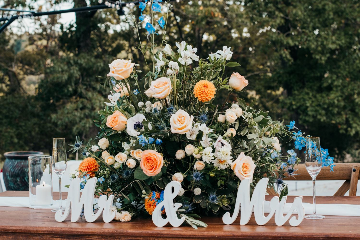 Wedding reception table decoration with 'Mr & Mrs' sign and peach floral arrangement.