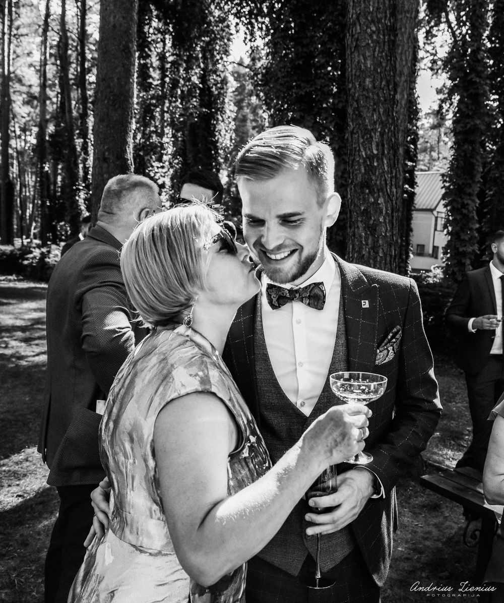 A candid black and white moment captured during an outdoor wedding celebration.
