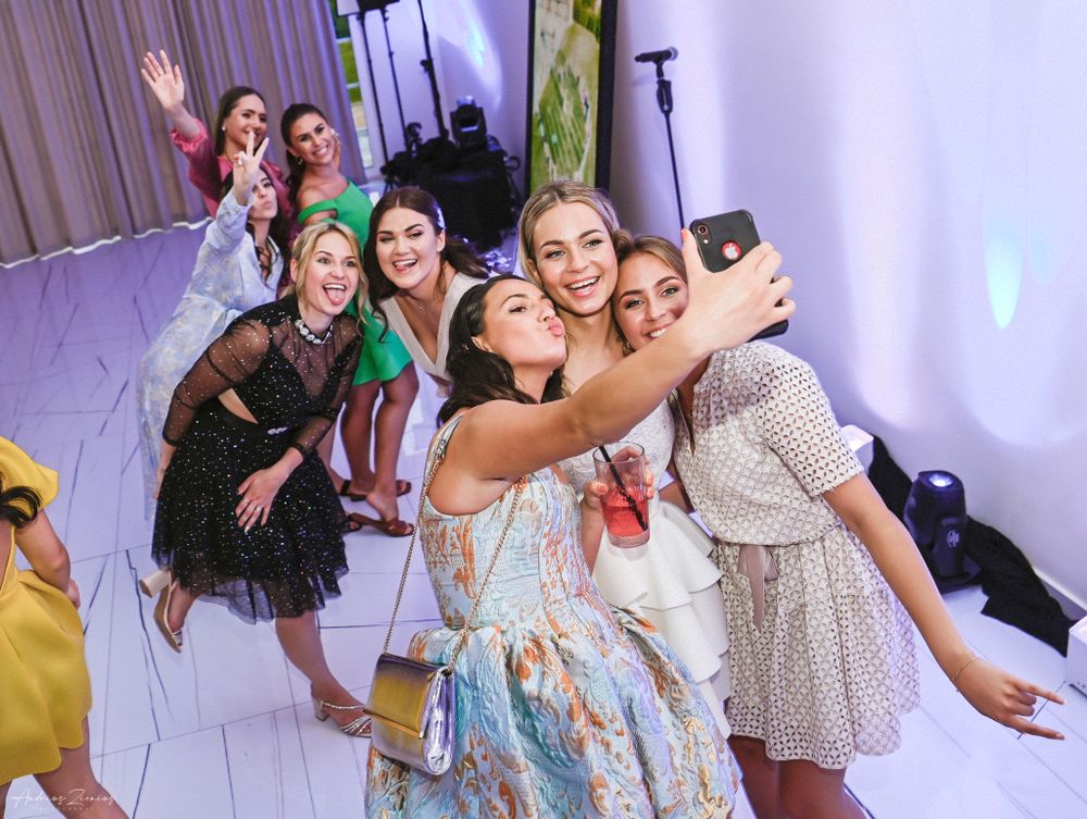 Lively dance party scene with colorful lighting at a wedding reception.