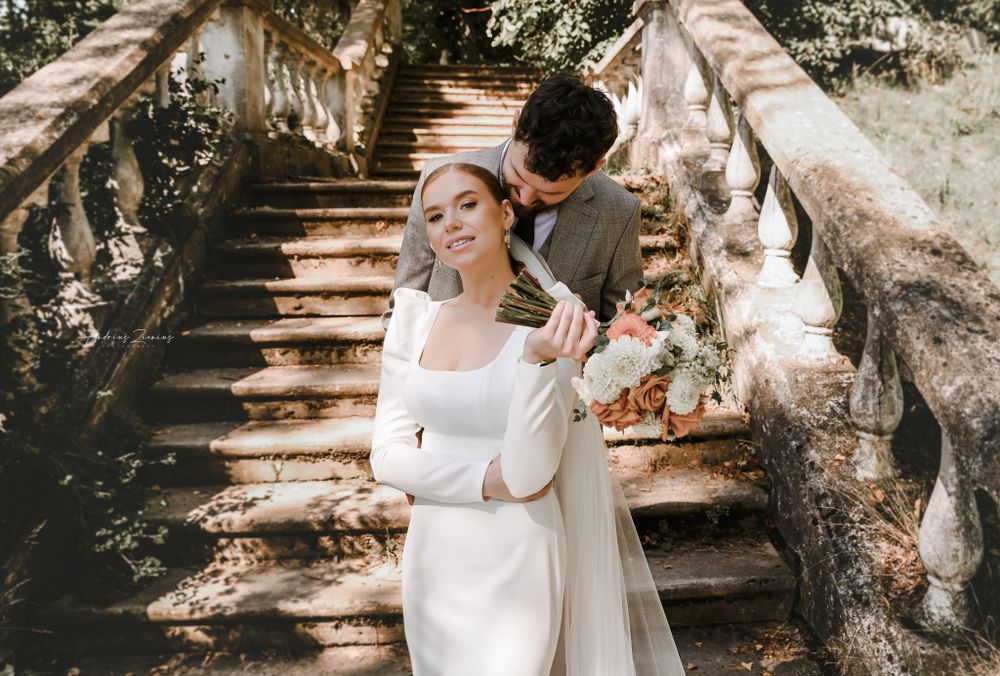 A romantic moment captured on historic stone steps during a wedding photoshoot.
