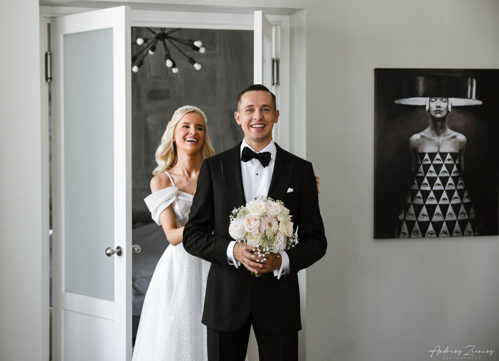 Wedding couple shares joyful moment in bright modern interior.