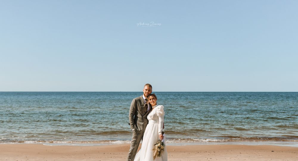 A romantic beach wedding ceremony at sunset with panoramic ocean views and sandy shores.
