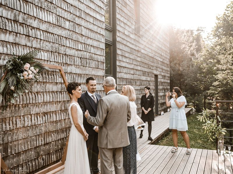 Wedding party walks along brick wall during outdoor ceremony with natural lighting.