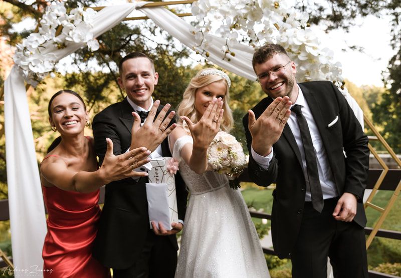 Joyful wedding celebration with guests cheering and throwing confetti outdoors.