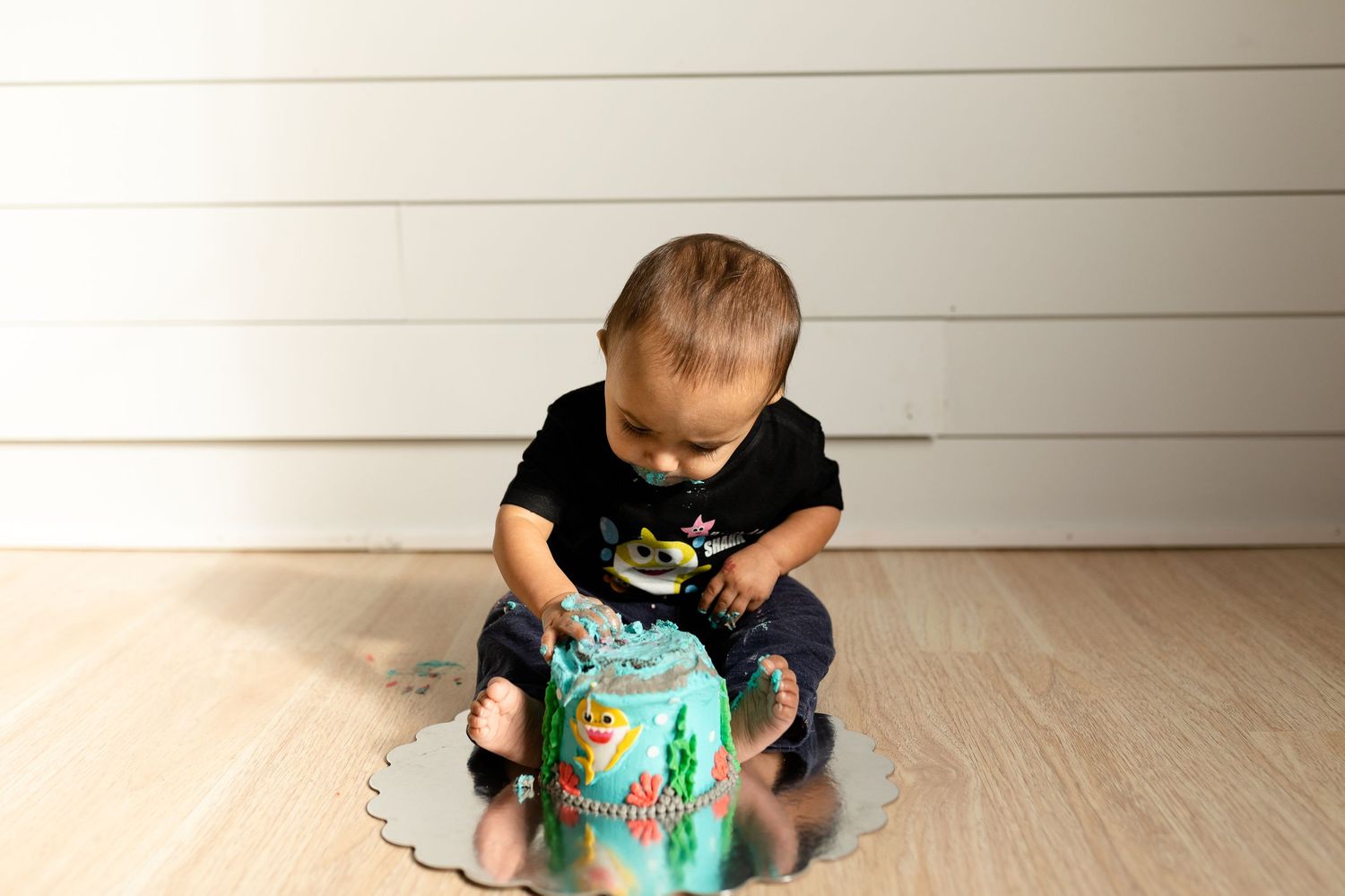 Children sharing a vibrant turquoise toy during indoor playtime.