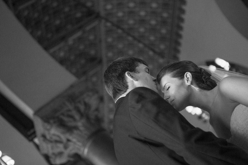 A black and white photo of a romantic moment between newlyweds during their first dance at a wedding reception.