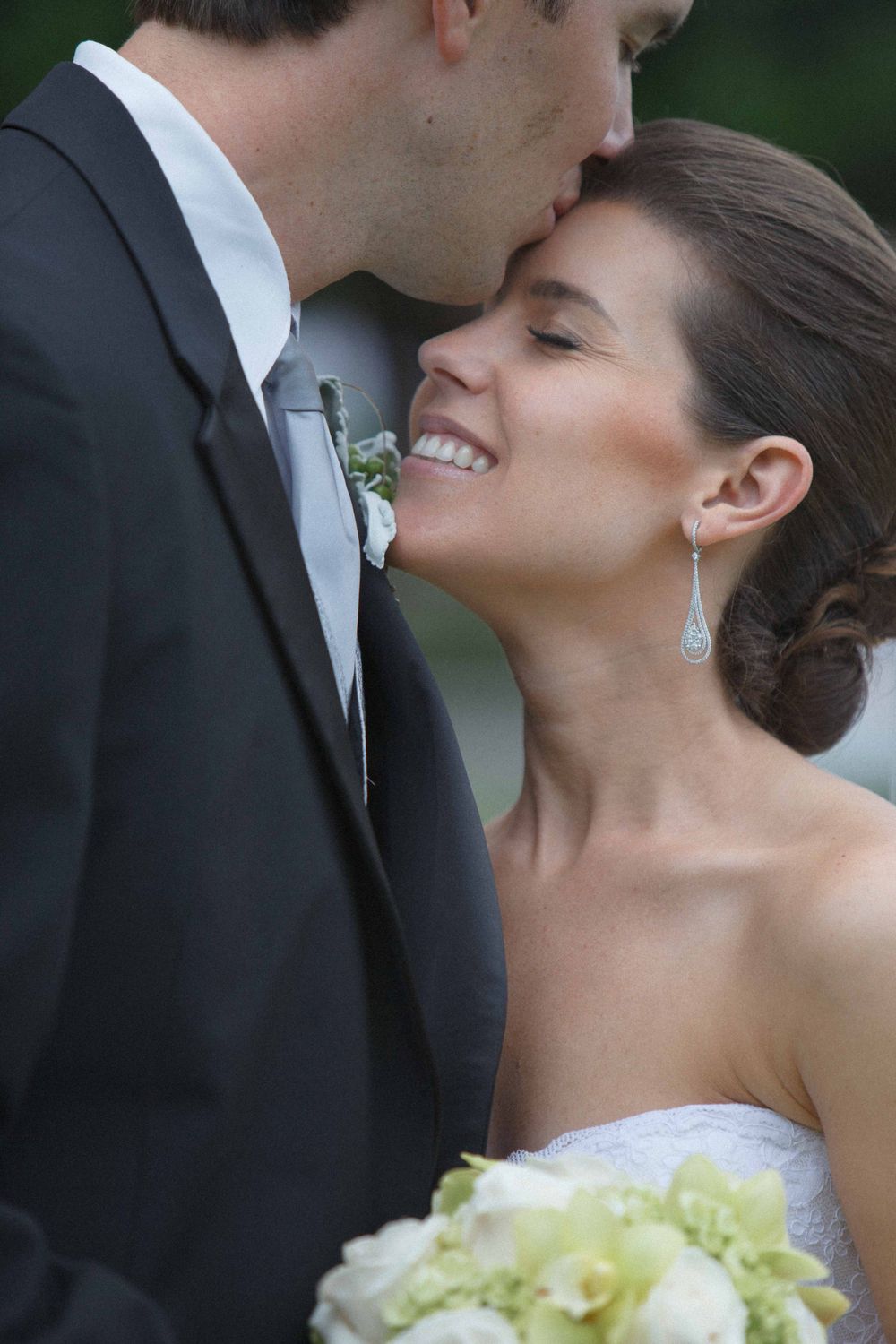 Romantic close-up sequence of newlyweds sharing intimate moments while the bride holds a light yellow bouquet.