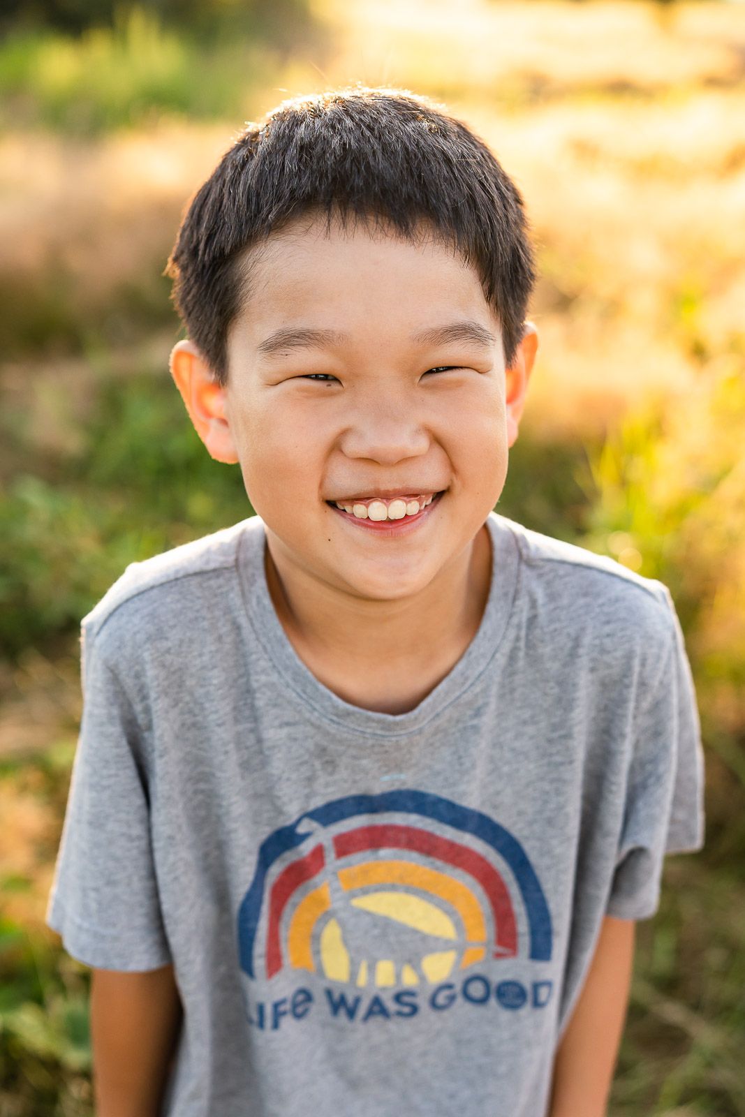 Smiling portrait of a boy backlit at golden hour