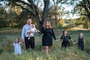 Candid family moment captured in a natural field setting during golden hour.