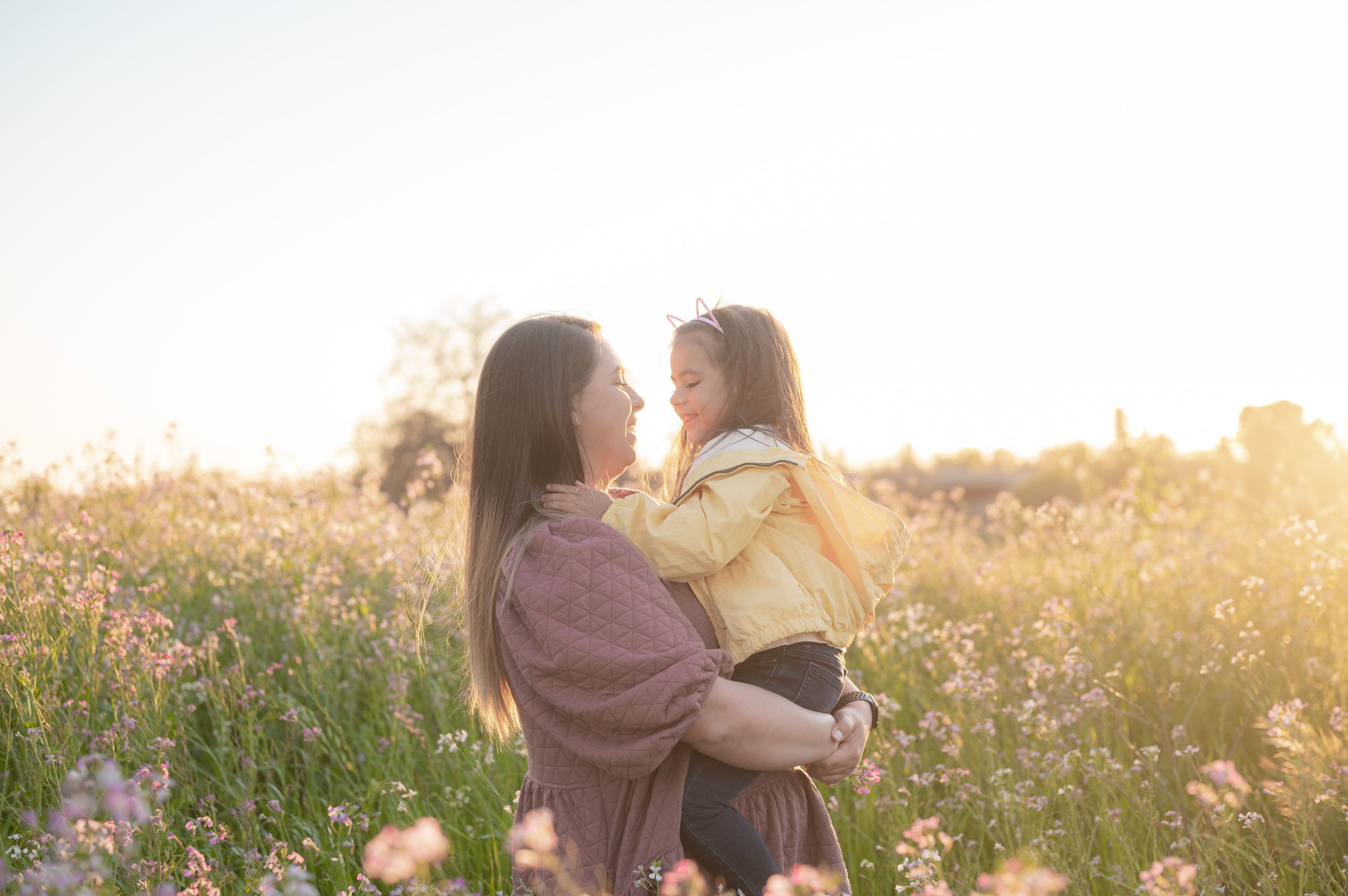 Heartwarming embrace captured in a wildflower meadow during sunset.