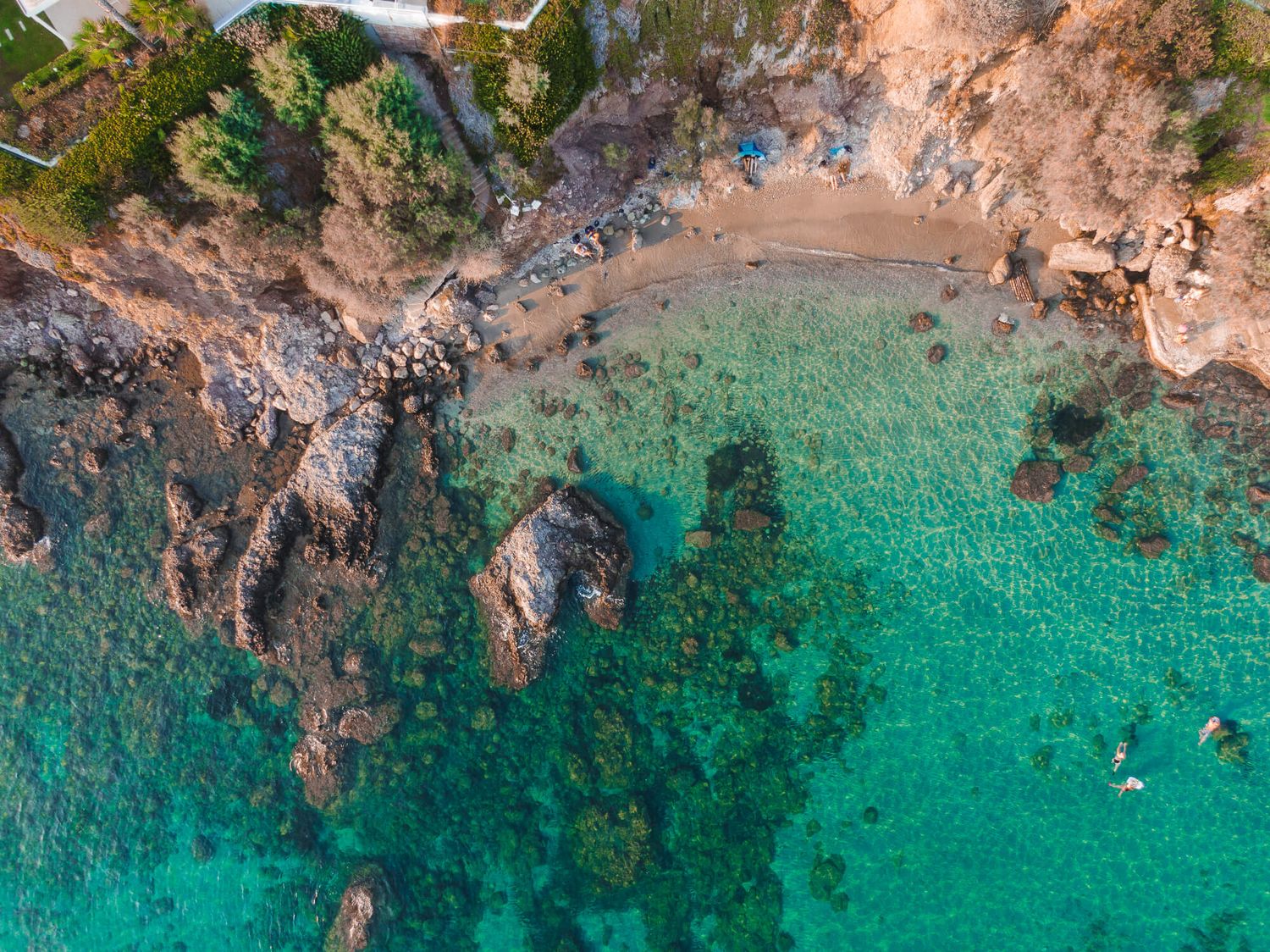 Aerial drone view of turquoise ocean water meeting rocky cliffs  from Greece  captured bt GeorgeNafpliotis.com