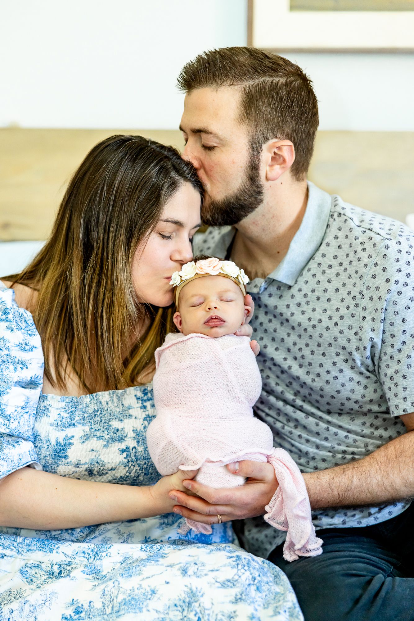 Mom kisses baby and dad kisses mom during newborn photos in Colorado Springs.