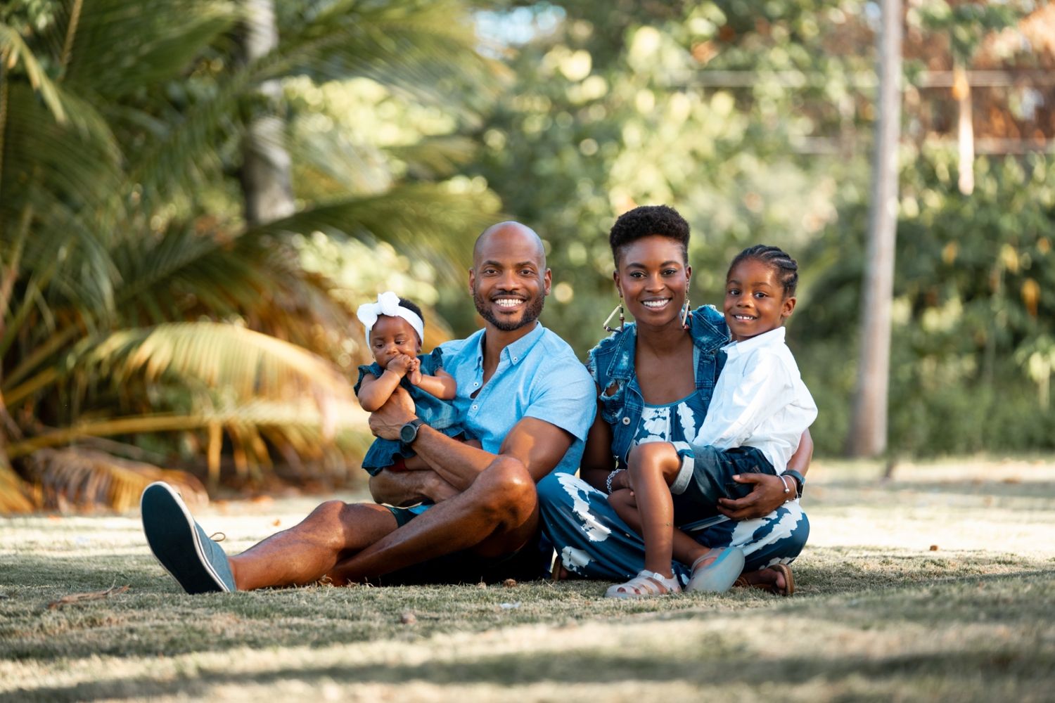 Family relaxing outdoors in matching blue outfits on a sunny day.