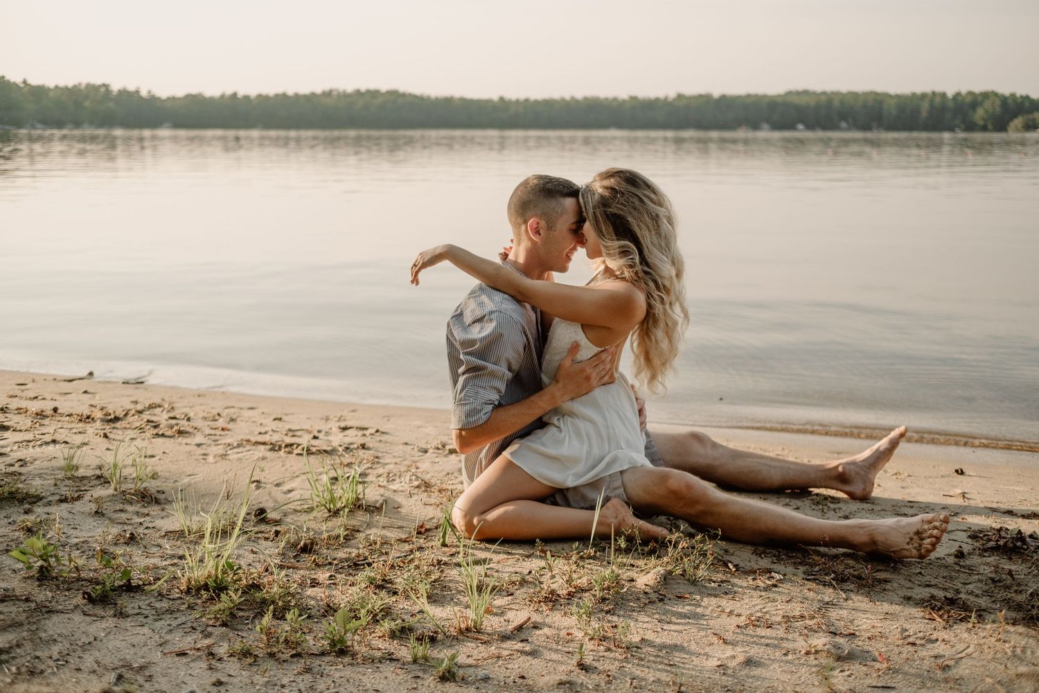 a couple on a sandy beach by a lake