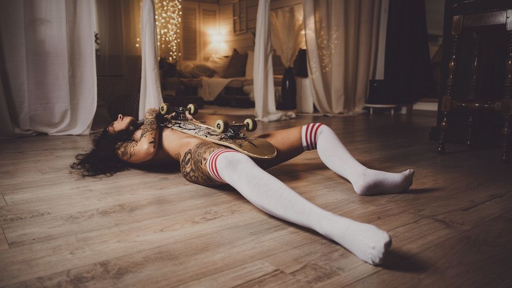 Artistic portrait on wooden floor with decorative lighting and white socks.