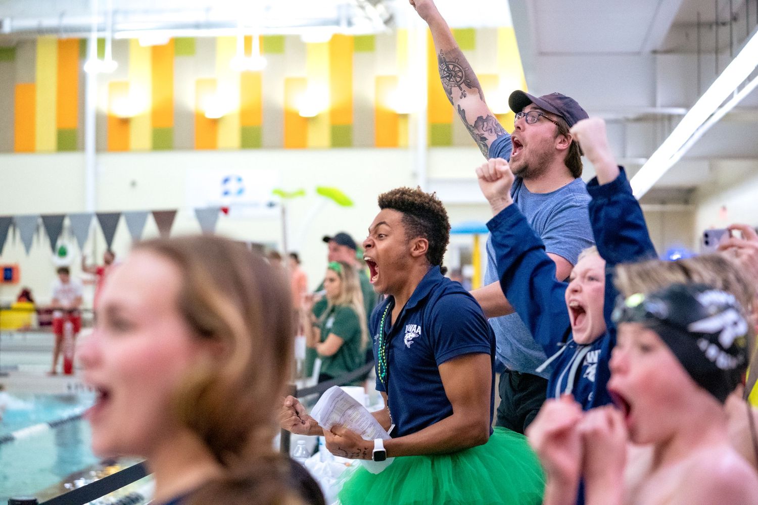 Spectators jump and cheer! Some with arms raised in celebration with one clenching their fists