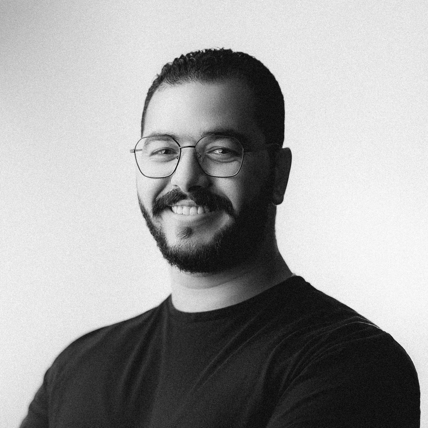 Studio headshots of man in black shirt showing various poses against white background.