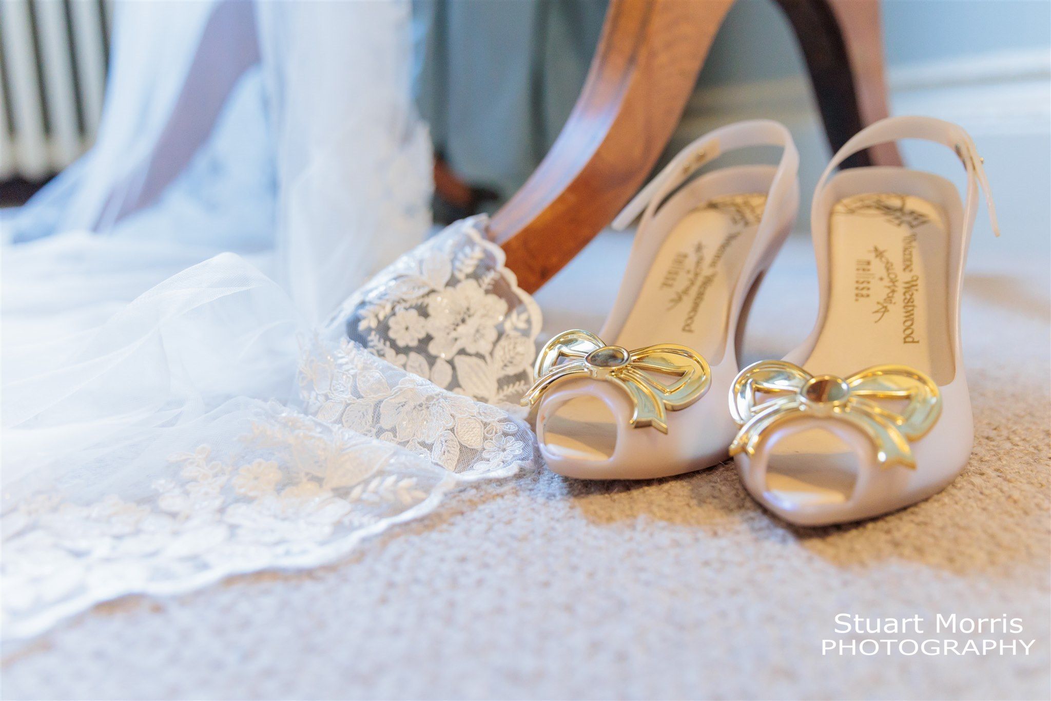 Brides shoes on the floor next to her veil trailing from a mirror. In Knowsley hall. Liverpool Wedding