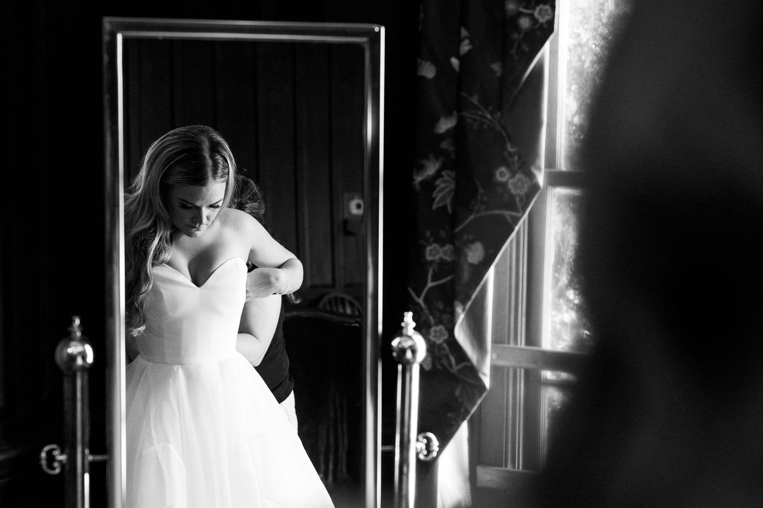 Dramatic black and white bridal portrait with artistic lighting and shadows.