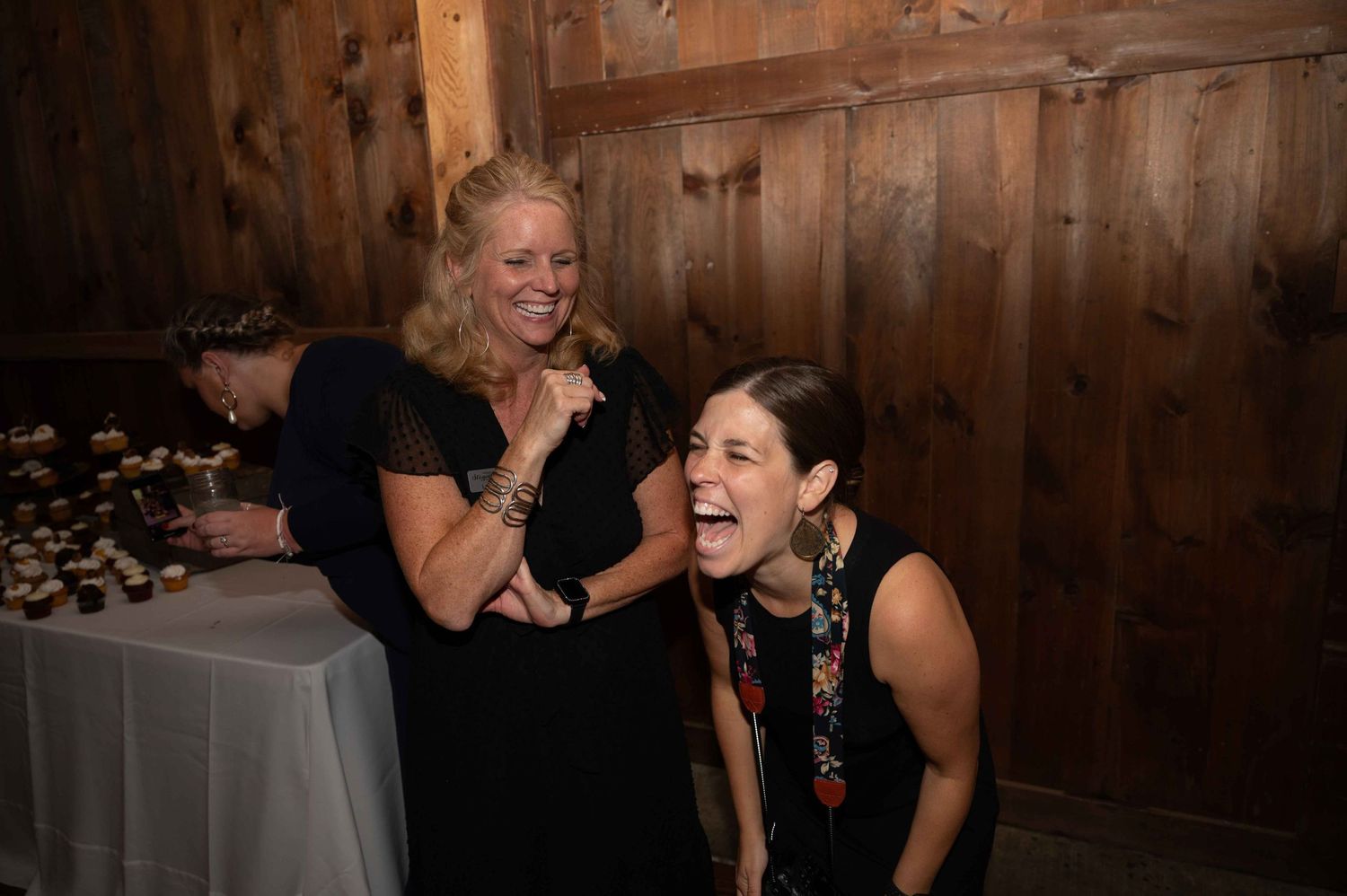 Two party guests sharing a joyful moment at an indoor celebration.