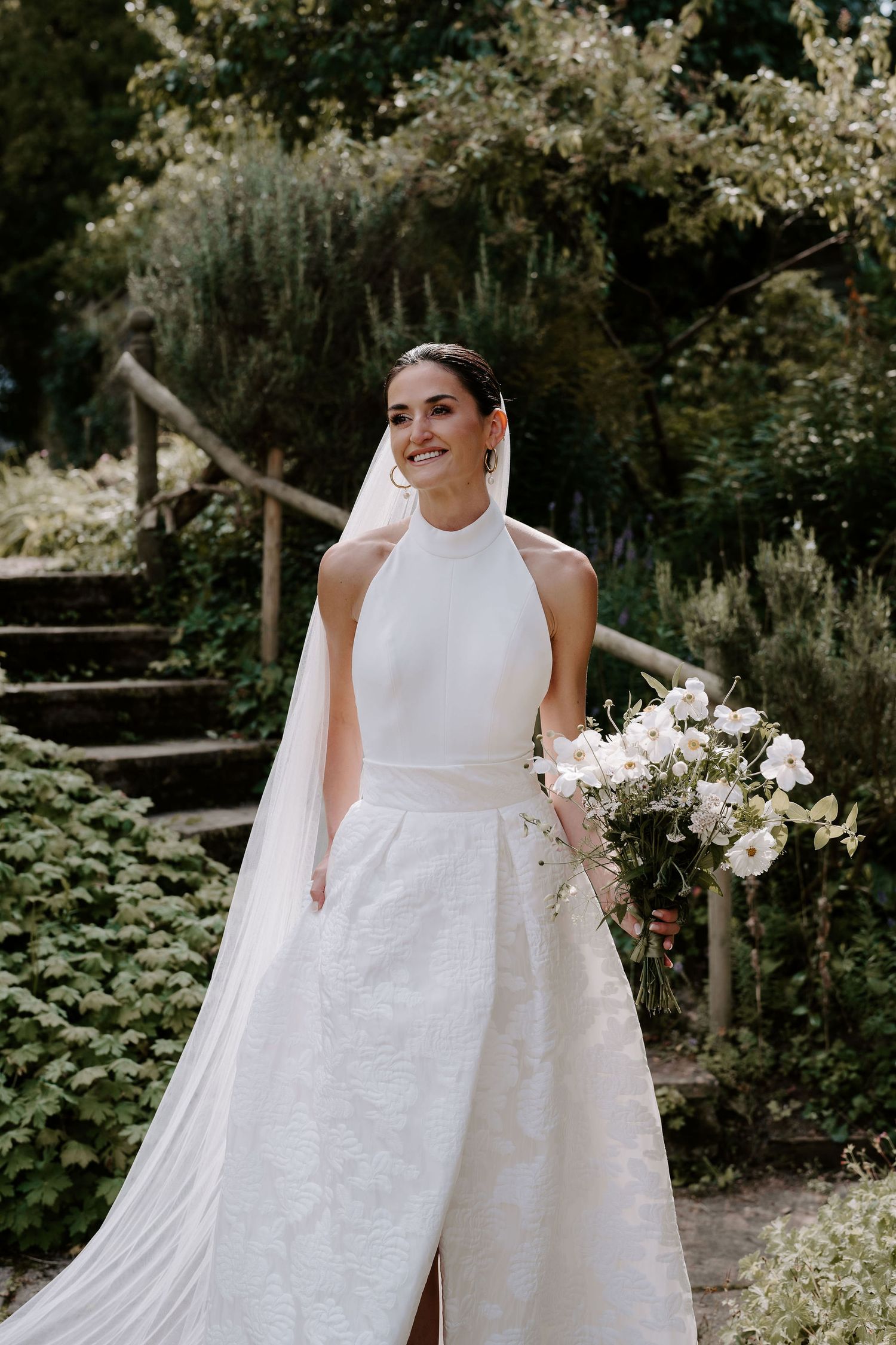 bride stood in gardens smiling before her wedding ceremony in oxfordshire