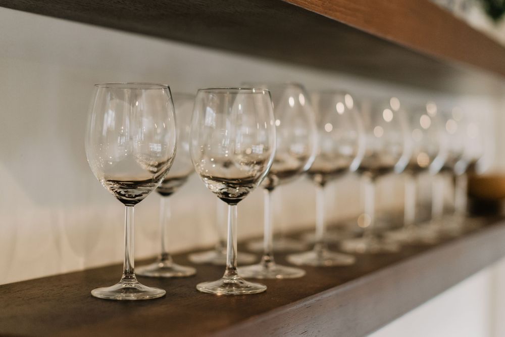 wine glasses lined up in a row on a shelf