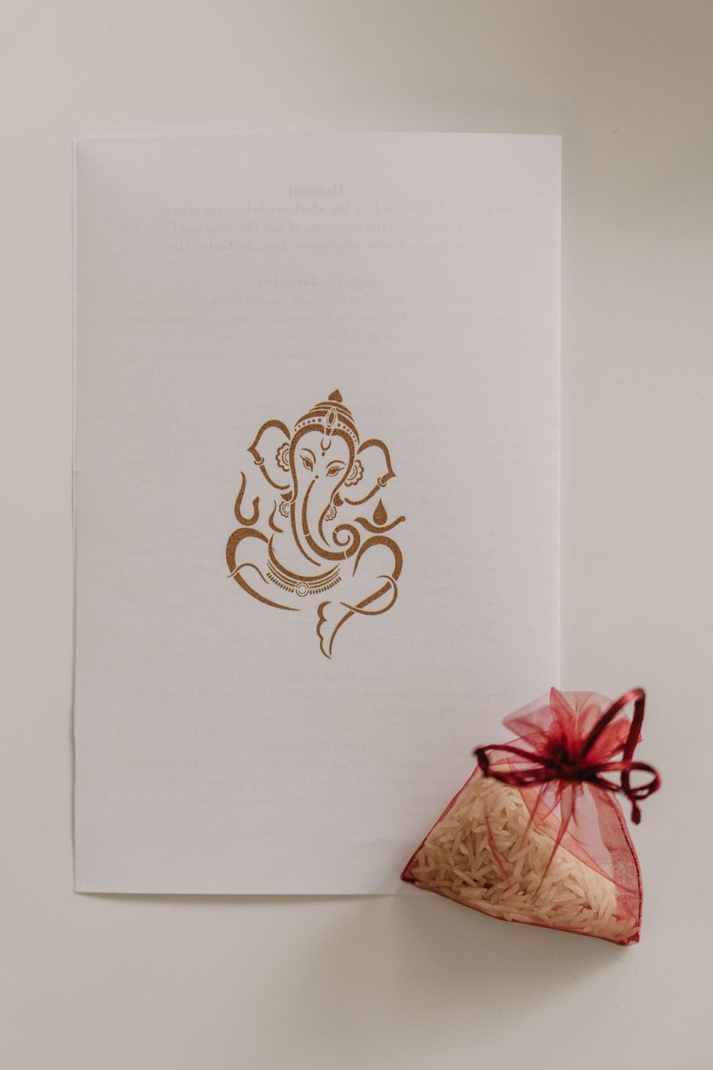 wedding invitation and a red bag of rice