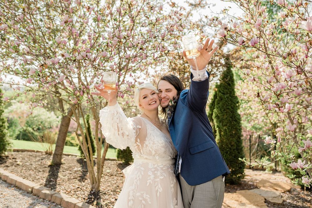 Spring wedding photography session under blooming cherry blossom trees.