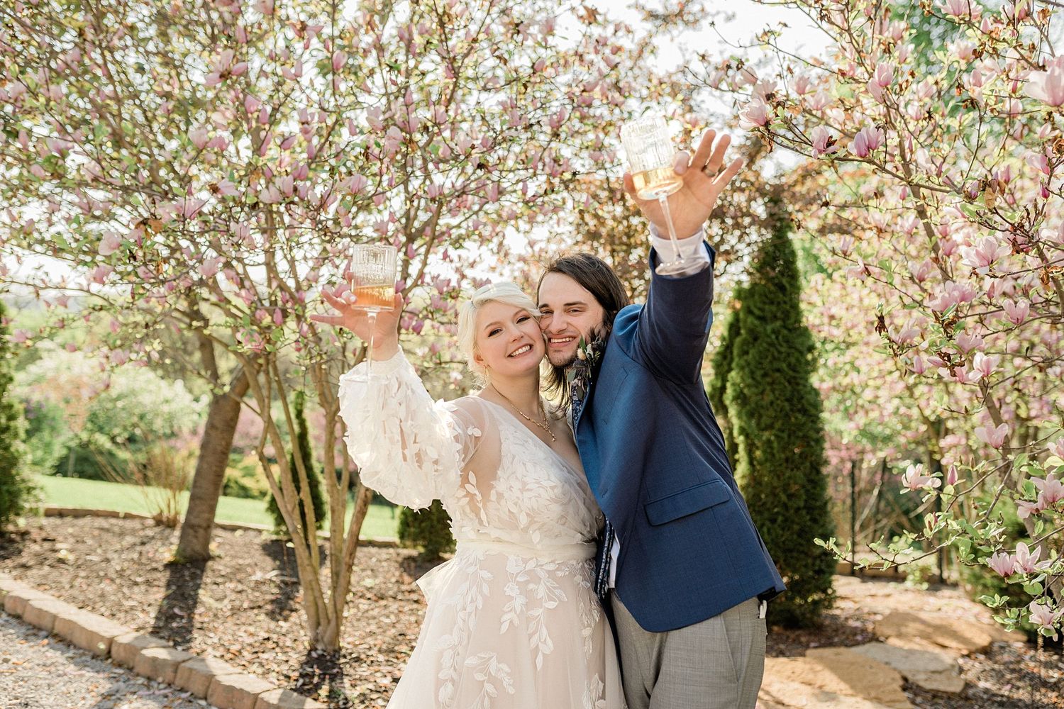 Spring wedding photography session under blooming cherry blossom trees.