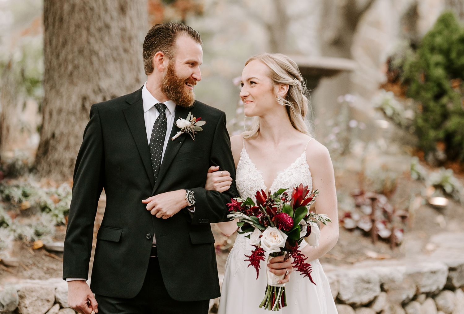 Bride and groom share intimate moments during their wedding photoshoot in a rustic outdoor setting.