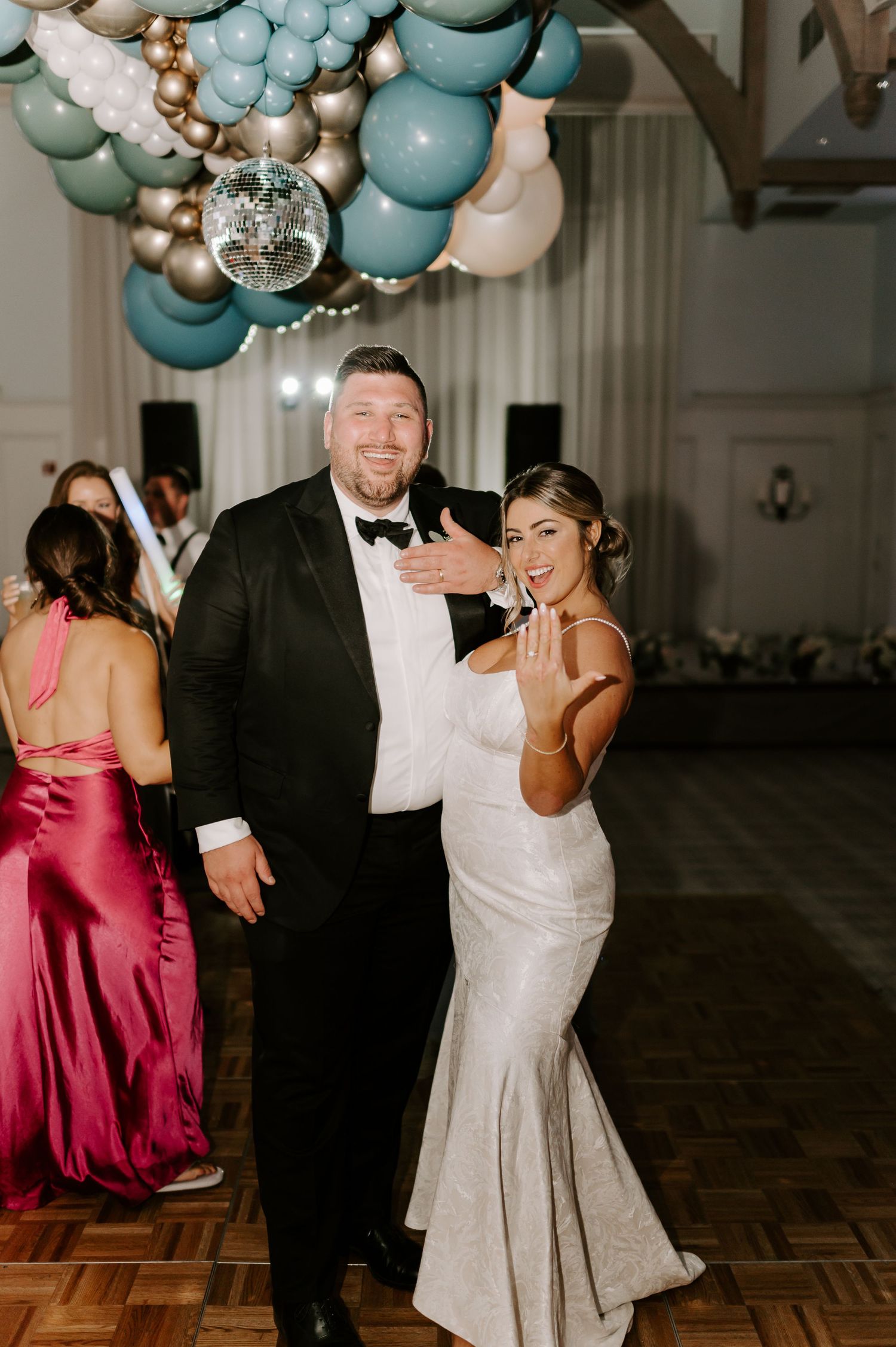 Wedding reception features dancing under a beautiful balloon installation in blue and silver.