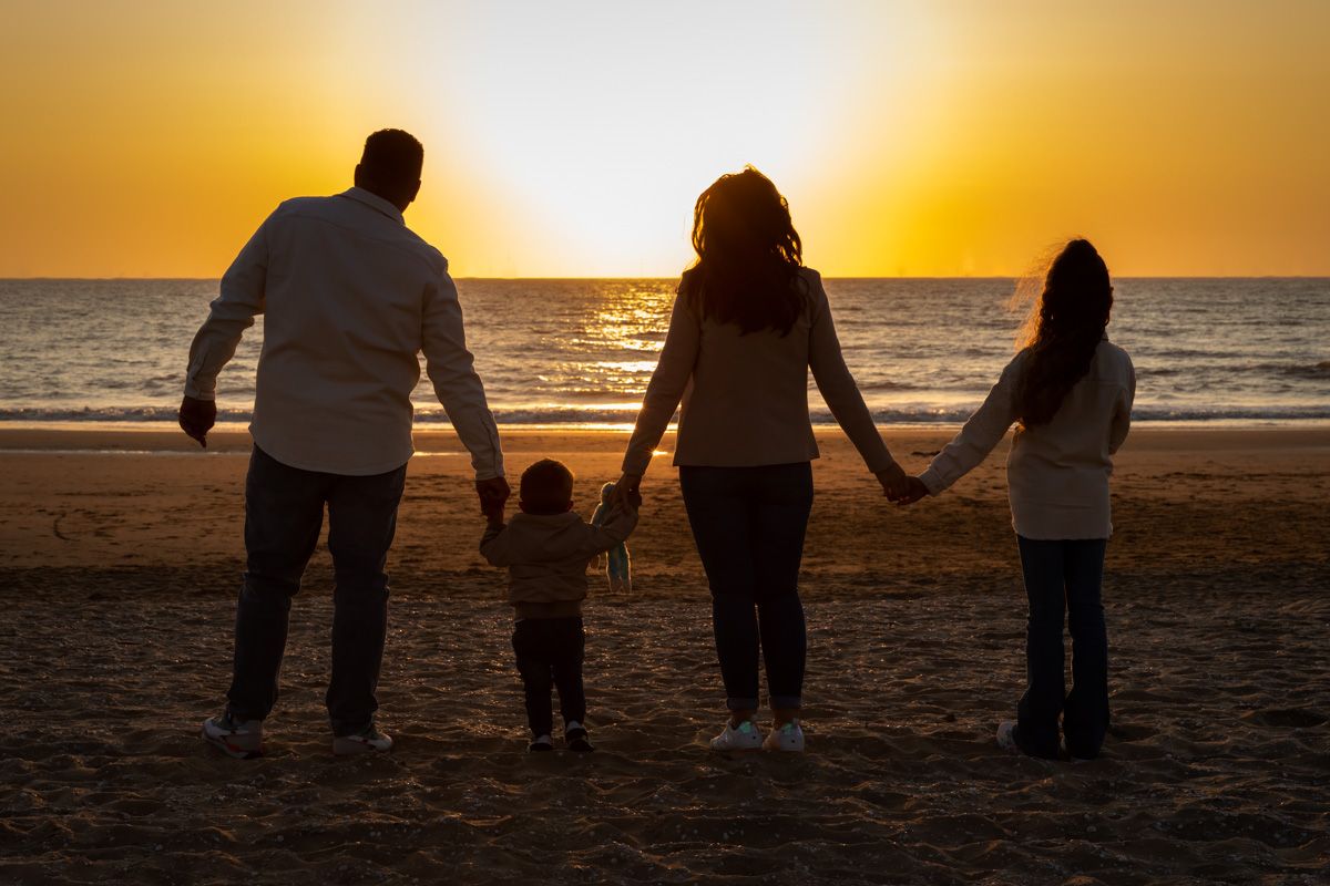 Barbara Kempeneers Fotografie Portret van gezin kijkend naar zonsondergang op het strand, gezinsshoot
