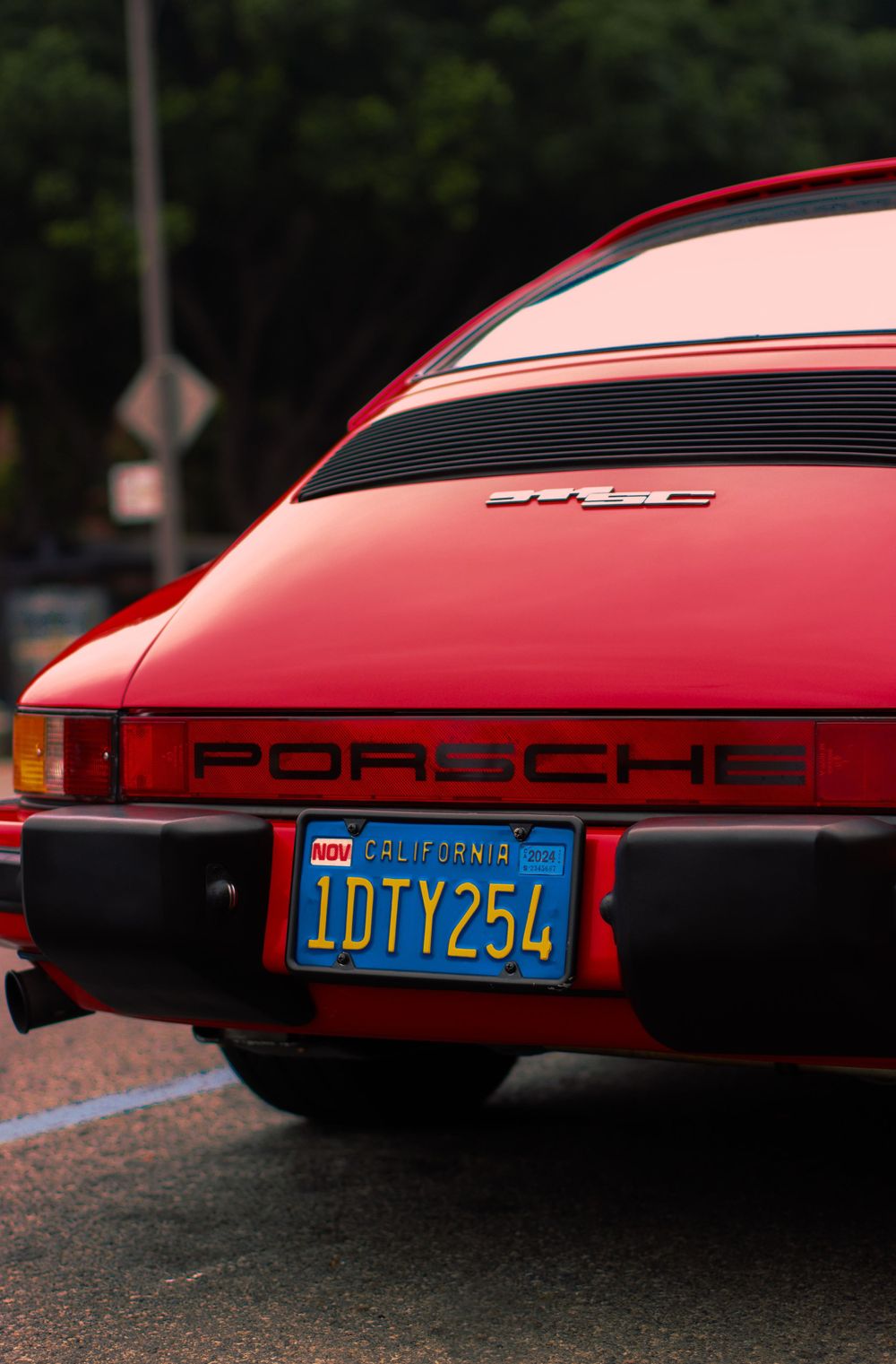 Rear view of a classic red Porsche 911SC with California license plate 1DTY254.