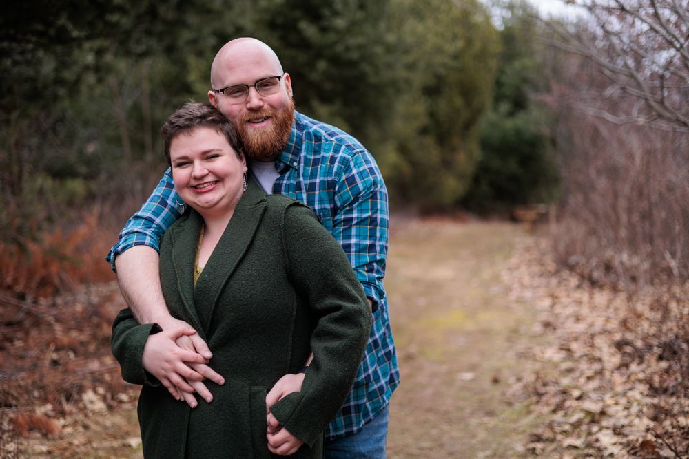 An intimate outdoor portrait session captures a couple's natural chemistry in a wooded setting.