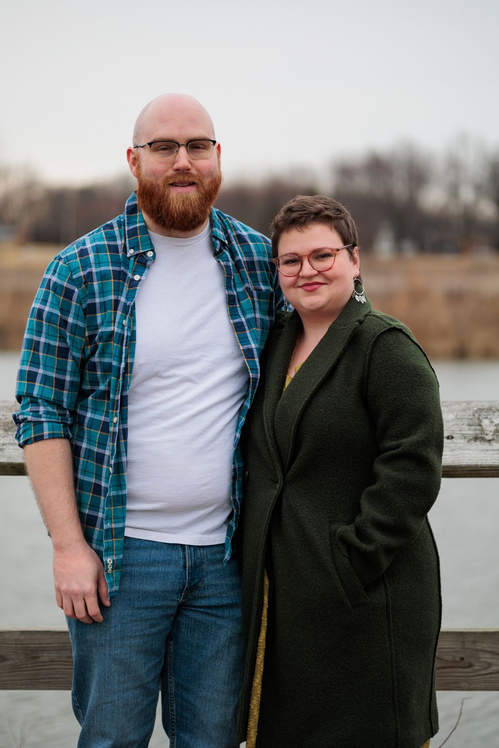 Couple in coordinating outfits posing together on wooden deck.