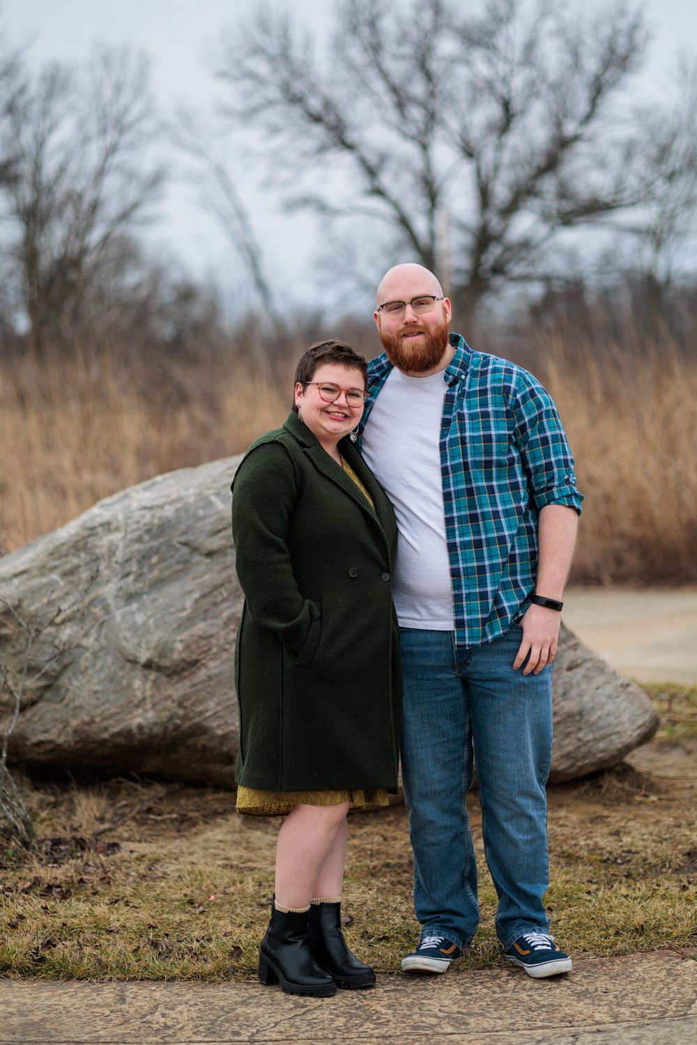 Family members posing near large rocks on outdoor path.