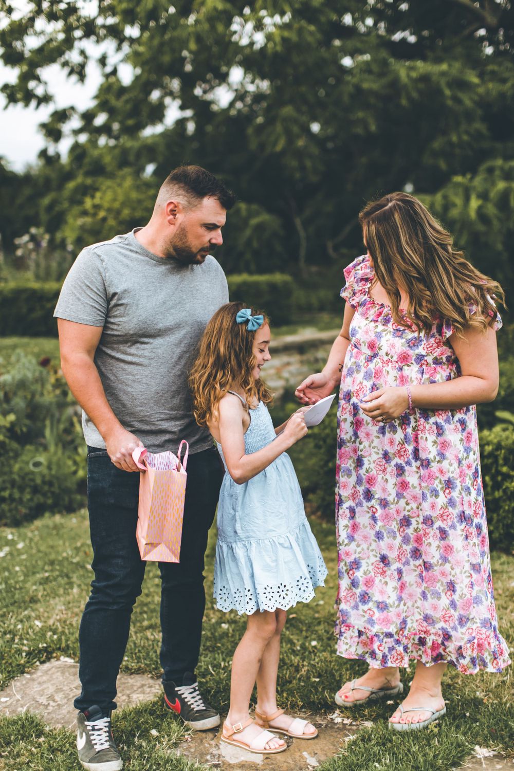 Family sharing a moment together in a garden setting with blooming flowers.