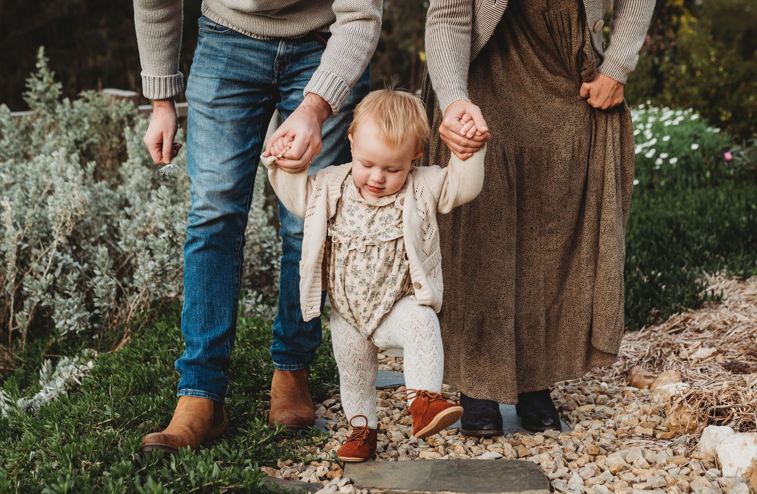 Family walking together on a grassy hillside path during autumn.