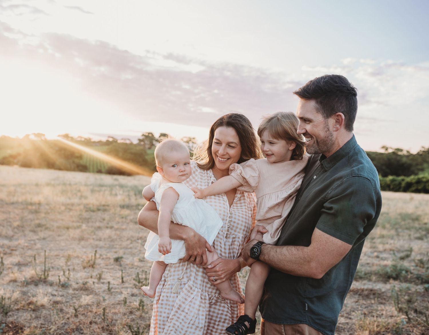 Family enjoying a sunset moment together in a field.