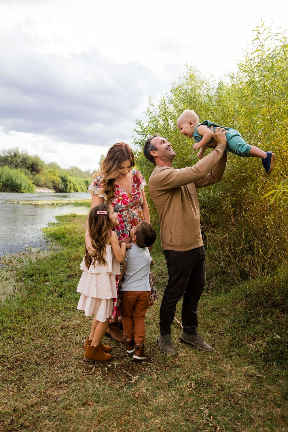 Family of five laughing and playing at the river during sunset in Arizona.