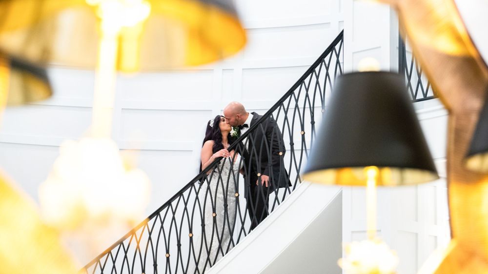Bride and groom staircase kiss at Water's Edge in Centerport, Long Island, NY.