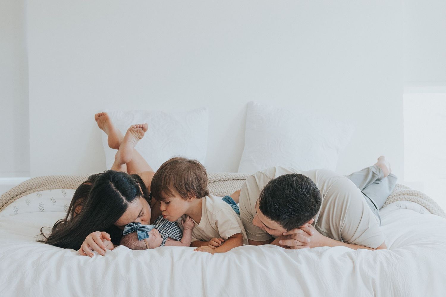 A family snuggles together during their in-home newborn photoshoot near American Fork Utah,