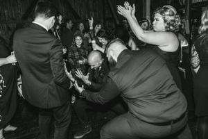 Black and white photo of energetic wedding reception dancing and celebrations.