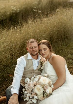 Intimate wedding portrait in a golden field at sunset.