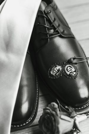 Black leather dress shoes and cufflinks arranged for a formal occasion.