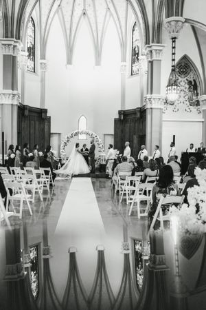 Gothic church interior with vaulted ceilings and white chairs set up for a wedding ceremony.