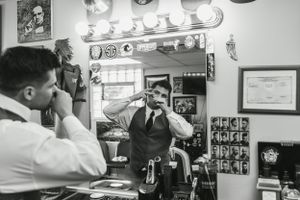 Black and white photo of barber shop interior with vintage styling.