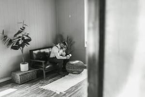 Black and white photo of a cozy interior scene with plants and furniture.