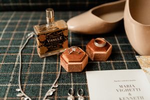 Perfume bottle, jewelry and invitation details on a patterned background.