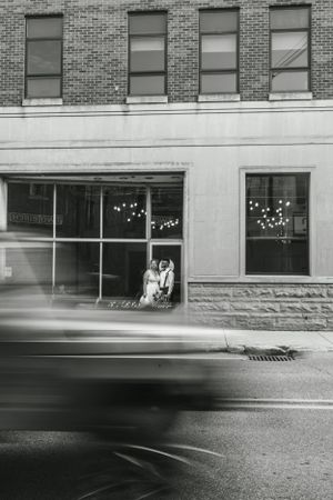 Black and white street photography of a storefront with motion blur from passing traffic.
